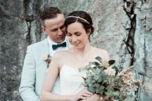 Brautpaar Brautpaar mit Brautstrauß vor einer natürlichen Felswand.